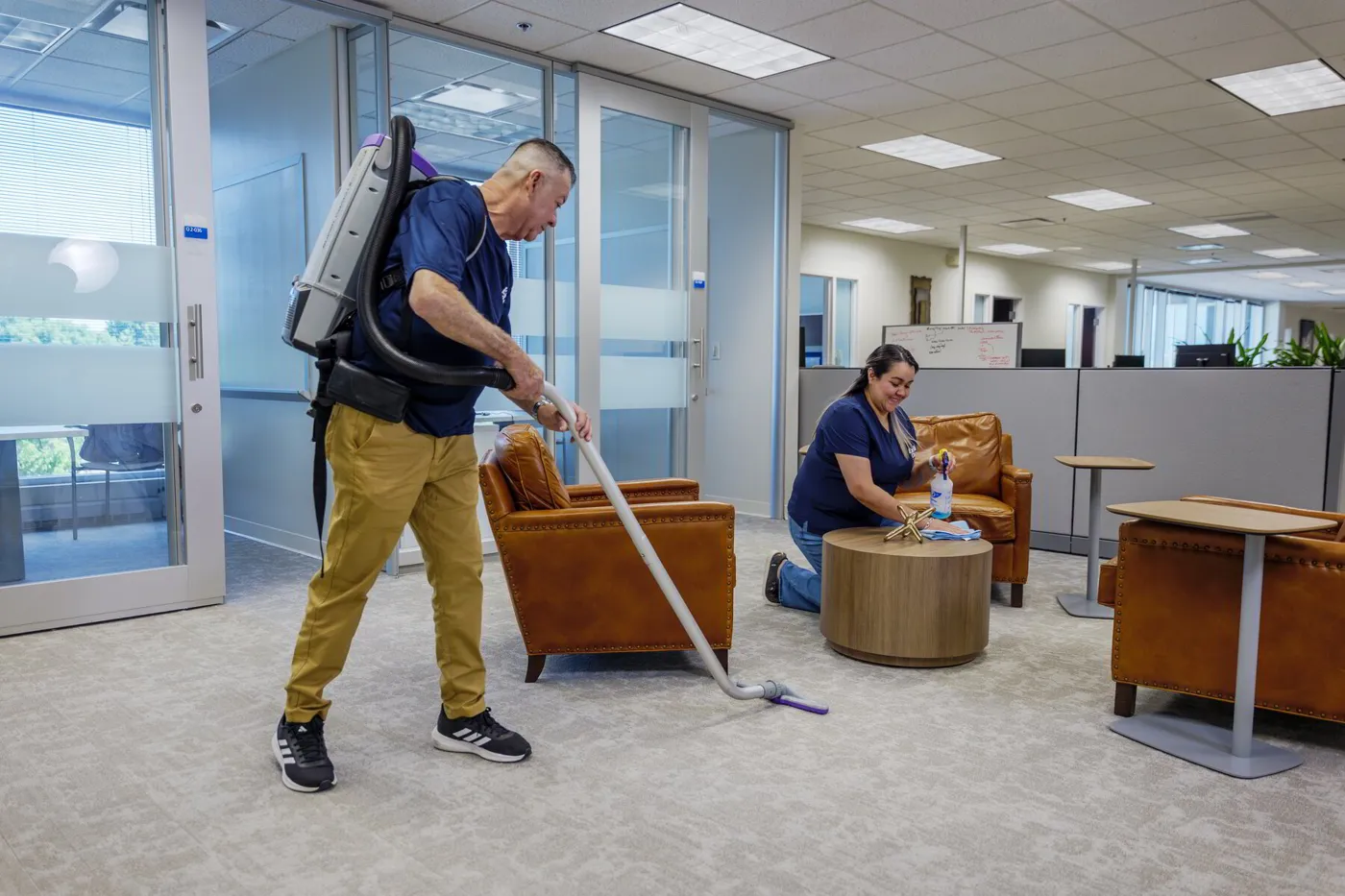 Two ExtraClean team members cleaning an office lounge